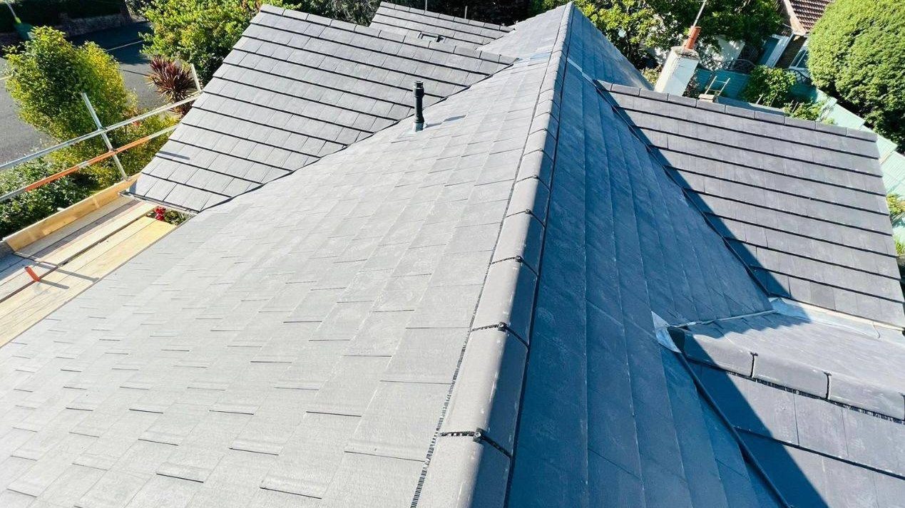 A new grey tiled hip roof completed by StoneRidge Roofing