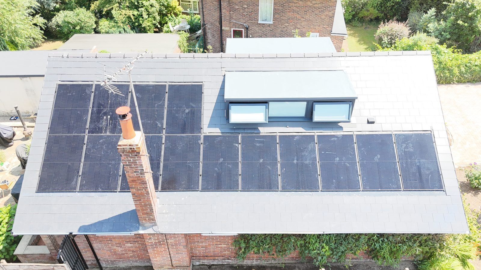 A finished StoneRidge Roofing re-roof with in-roof solar panels and a new flat-roofed dormer, seen from above