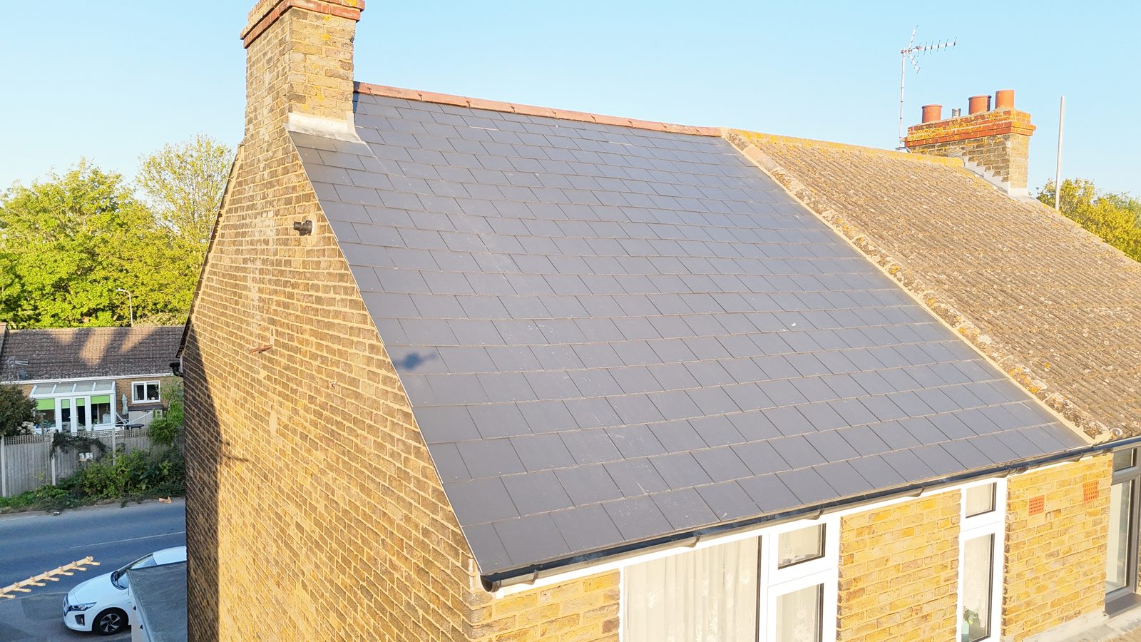 A semi-detached house freshly re-roofed in slate by StoneRidge Roofing, seen from the drone in evening light